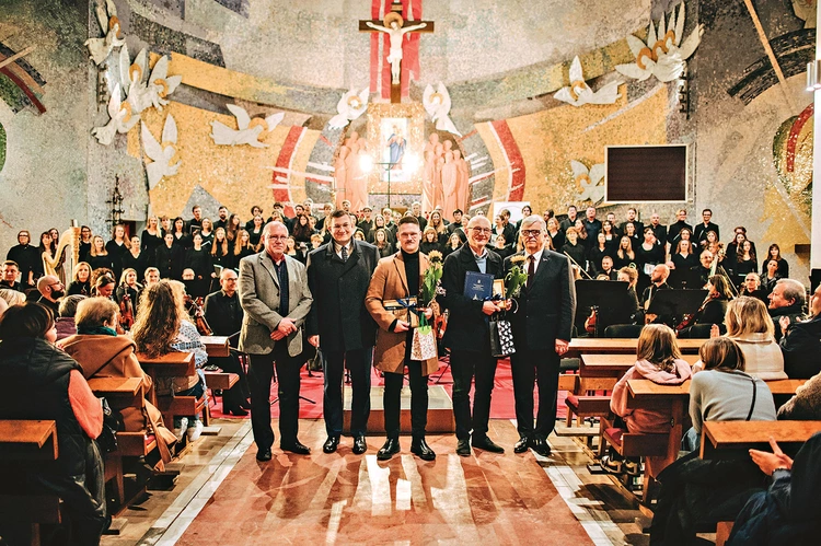 Na zdjęciu (od lewej): Daniel Ptach, dyrektor Międzynarodowego Festiwalu Muzyki Religijnej  im. ks. S. Ormińskiego, Marcin Kurkowski, sekretarz miasta Rumi, Mikołaj Gąsiewski, kompozytor, prof. Kazimierz Nowosielski, autor tekstu, oraz Kazimierz Klawiter, przedstawiciel Społecznego Komitetu Obchodów 800-lecia Rumi. W tle chórzyści i orkiestra.