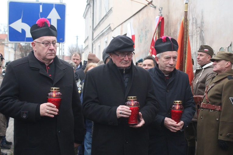 Biskup Szymon Stułkowski, ks. inf. Wiesław Kosek i ks. kan. dr Janusz Kochański w miejscu pamięci złożyli płonące znicze.