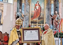 	Bp Roman Pindel i kustosz ks. Jacek Kobiałka prezentują dekret.