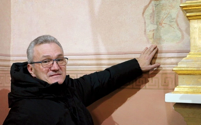 	Ks. proboszcz Bogdan Zalewski wskazuje na odkryte niedawno fragmenty XIV-wiecznej polichromii.
