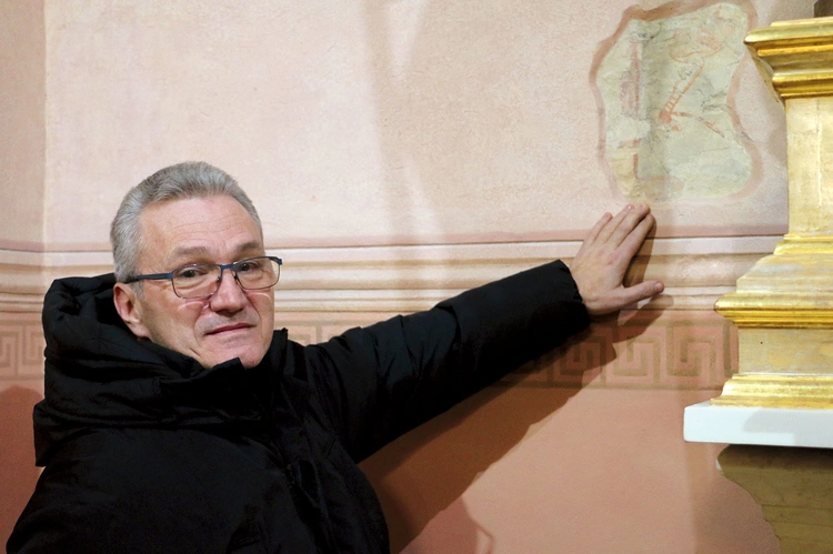 	Ks. proboszcz Bogdan Zalewski wskazuje na odkryte niedawno fragmenty XIV-wiecznej polichromii.