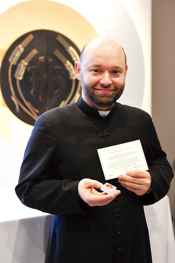 	Ksiądz Damian Drop prezentuje relikwie.