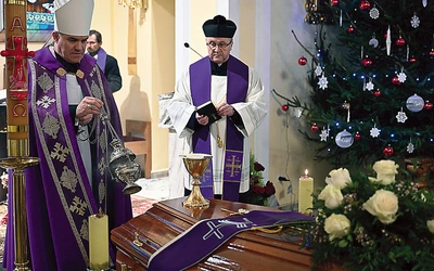Biskup okadza trumnę z ciałem.