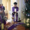 Biskup okadza trumnę z ciałem.