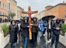 Pielgrzymi idą z krzyżem do bazyliki św. Piotra.
