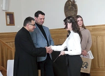 Ks. Grzegorz Gruszecki i dyrektor I LO Jacek Biłko, którzy ponownie patronują konkursowi, z laureatkami ubiegłorocznej gali.