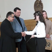 Ks. Grzegorz Gruszecki i dyrektor I LO Jacek Biłko, którzy ponownie patronują konkursowi, z laureatkami ubiegłorocznej gali.