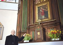 	Ks. Szymon Mucha obok ołtarza, przy którym modlą się pary.