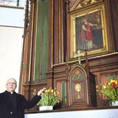 	Ks. Szymon Mucha obok ołtarza, przy którym modlą się pary.