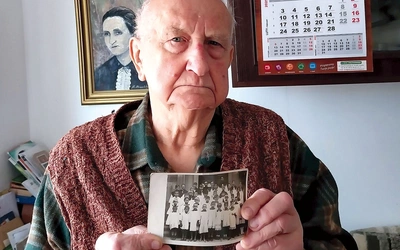 	Stanisław Talaga ze zdjęciem grupy ministranckiej z 1945 roku. Za nim na ścianie wisi portret jego mamy Magdaleny,  która spowiadała się u sługi Bożego.