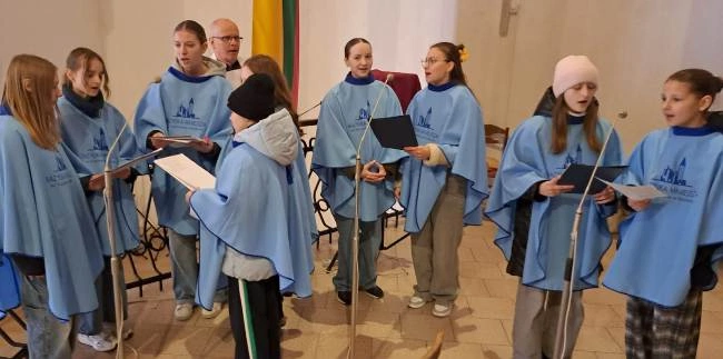 Proboszcz ks. Jarosław Wojtkun ze scholą parafialną.