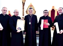 Księża z dekretami z bp. R. Pindlem w kaplicy kurii.