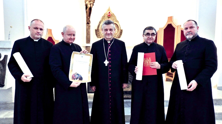 Księża z dekretami z bp. R. Pindlem w kaplicy kurii.