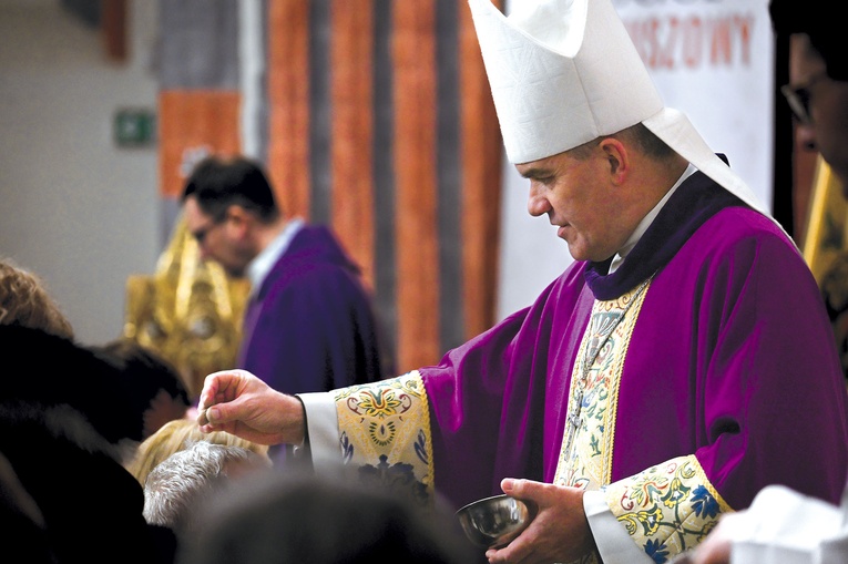 	Biskup posypuje popiołem głowy wiernych w koszalińskiej katedrze.