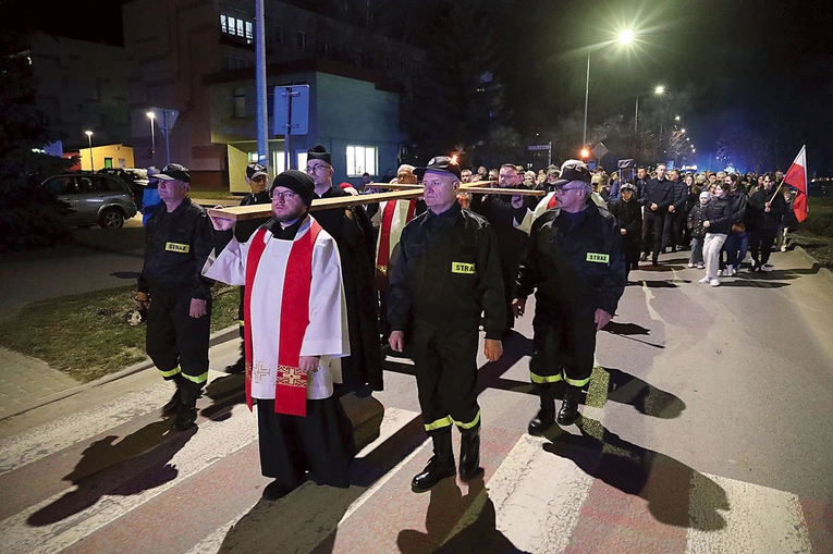 Zgromadzeni podążali za krzyżem, niosąc flagi i emblematy patriotyczne.