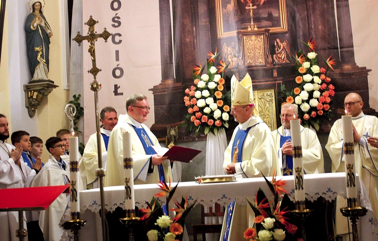 Bp Sławomir Oder przekazuje dekret kustoszowi ks. Marcinowi Wojtczakowi.