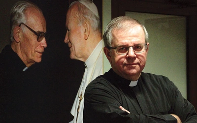 Ks. Grzegorz przy zdjęciu Jana Pawła II – to jego kazanie poruszyło serca ludzi biznesu.