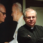 Ks. Grzegorz przy zdjęciu Jana Pawła II – to jego kazanie poruszyło serca ludzi biznesu.