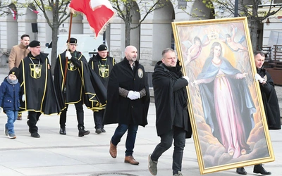 Mężczyźni noszą duży obraz  Matki Bożej Łaskawej  i sztandar św. Andrzeja Boboli.