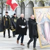 Mężczyźni noszą duży obraz  Matki Bożej Łaskawej  i sztandar św. Andrzeja Boboli.