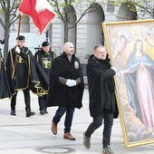 Mężczyźni noszą duży obraz  Matki Bożej Łaskawej  i sztandar św. Andrzeja Boboli.