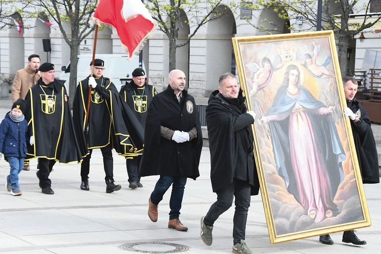 Mężczyźni noszą duży obraz  Matki Bożej Łaskawej  i sztandar św. Andrzeja Boboli.