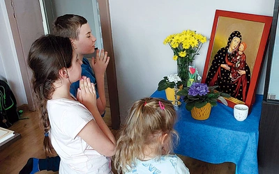 Szymon, Michalina i Maja Piechula przed ikoną. 