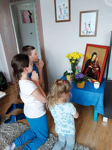 Szymon, Michalina i Maja Piechula przed ikoną. 