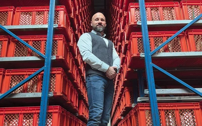 Krzysztof Szymański w magazynie wysokiego składowania, w którym przechowywane są książki.   