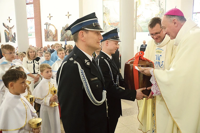 W procesji z darami strażacy przynieśli naczynie na wodę święconą. 