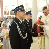 W procesji z darami strażacy przynieśli naczynie na wodę święconą. 