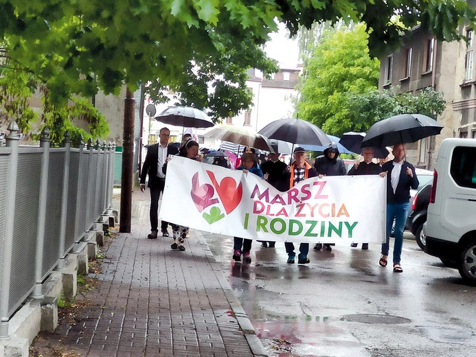 Wszyscy wytrwale maszerowali pod parasolami i w pelerynach.