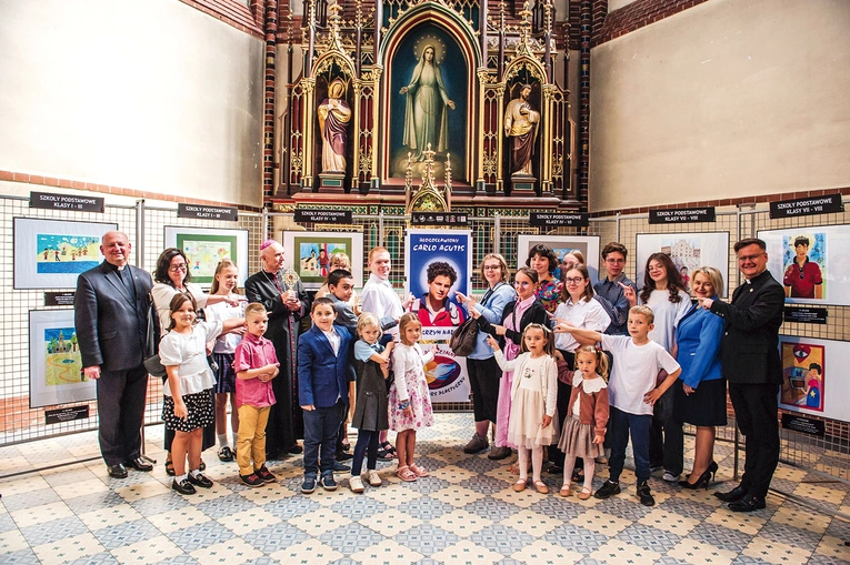 Laureaci z bp. Andrzejem Iwaneckim i organizatorami przedsięwzięcia podczas otwarcia wystawy narodzonych prac w gliwickiej katedrze, gdzie można je oglądać do 20 lipca.