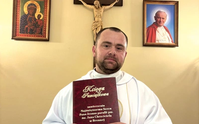 Duszpasterz ośrodka dla osób starszych z Księgą Zawierzenia parafii św. Jana Chrzciciela.