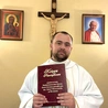Duszpasterz ośrodka dla osób starszych z Księgą Zawierzenia parafii św. Jana Chrzciciela.