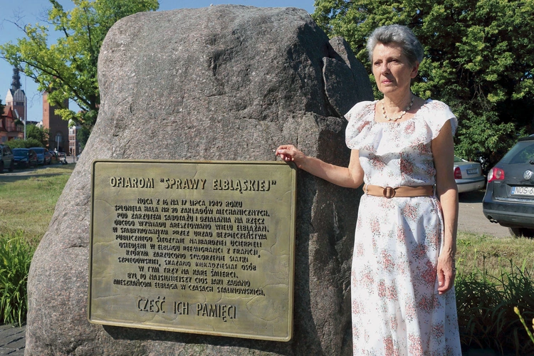Grażyna Wosińska przy pomniku poświęconym ofiarom stalinowskiego terroru  po wydarzeniach z 17 lipca 1949 r.