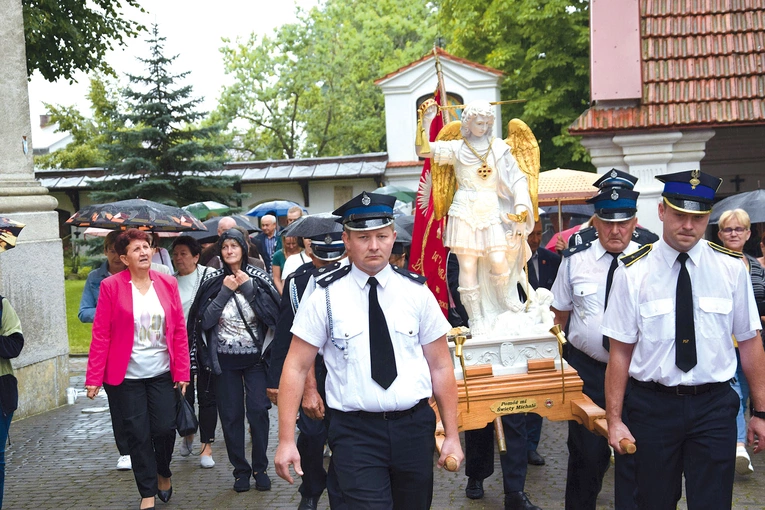 Strażacy wnoszą figurę świętego.