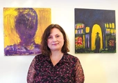 Agnieszka Paluch obok obrazów „Spotkanie Nikodema z Jezusem”  oraz „Autoportret”. 