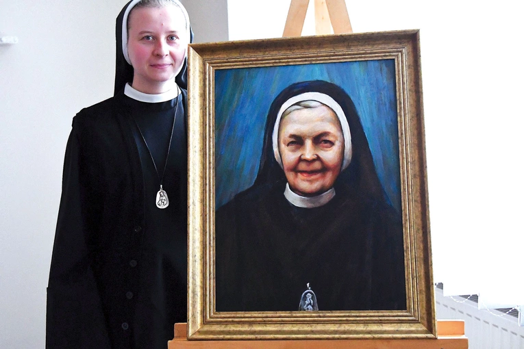 Wicepostulatorka s. M.W. Szelejewska przy portrecie służebnicy Bożej. Iwona Król urodziła się 12 maja 1908 r. na Kaszubach, a w 1930 r. wstąpiła do Zgromadzenia Sióstr św. Elżbiety w Poznaniu. Po wybuchu II wojny światowej trafiła najpierw do Wrocławia, a następnie do Wschowy. Odznaczała się głęboką pobożnością, samarytańską miłością względem bliźnich, heroiczną odwagą i patriotyzmem. W czasie wojny odmówiła podpisania volkslisty. Po wkroczeniu do Wschowy wojsk radzieckich z narażeniem życia strzegła powie…