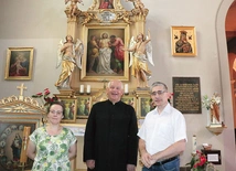 Proboszcz wspólnoty ks. Józef Milan i jej historycy – dr Barbara Hryszko i prof. Rafał Hryszko – przed ołtarzem patrona.