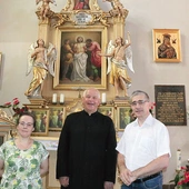 Proboszcz wspólnoty ks. Józef Milan i jej historycy – dr Barbara Hryszko i prof. Rafał Hryszko – przed ołtarzem patrona.