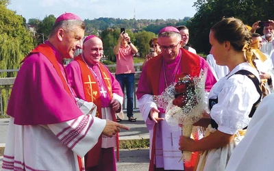 Biskupi  (od prawej) Roman Pindel, Piotr Greger i Martin David podczas powitania na przeprawie.