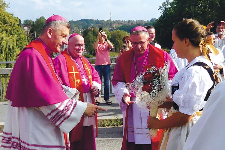 Biskupi  (od prawej) Roman Pindel, Piotr Greger i Martin David podczas powitania na przeprawie.