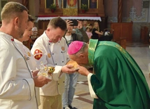 Biskup Solarczyk całuje chleb w radomskiej katedrze.
