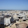 Wysiedlone rodziny palestyńskie przebywają w obozie dla uchodźców w mieście Gaza, w pobliżu nadmorskiej drogi