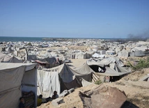 Wysiedlone rodziny palestyńskie przebywają w obozie dla uchodźców w mieście Gaza, w pobliżu nadmorskiej drogi