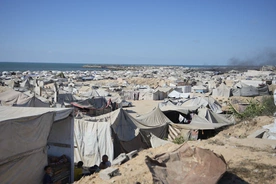 Wysiedlone rodziny palestyńskie przebywają w obozie dla uchodźców w mieście Gaza, w pobliżu nadmorskiej drogi