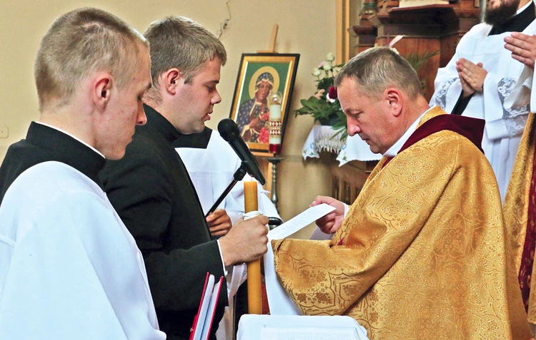 Obrzęd przyjęcia przyrzeczenia zakonnego. Kandydat trzyma świecę i wypowiada słowa ślubowania.