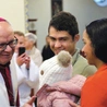 Biskup opolski przekazuje znak pokoju rodzinie Kolumbijczyków mieszkających w Opolu: Oneliz, Guillermo i ich córeczce Grecii.