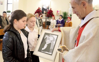 Dzieci ze szkoły w Łękawce w procesji z darami przynoszą zdjęcia ks. Jana Marszałka.